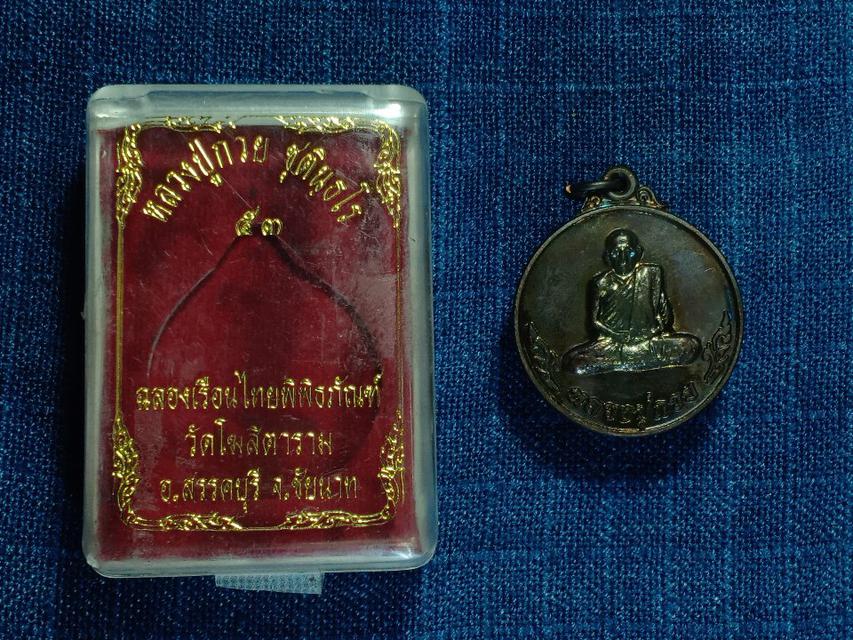 เหรียญ หลวงพ่อกวย ชุตินธโร รุ่นฉลองเรือนไทยพิพิธภัณฑ์ วัดโฆสิตาราม ชัยนาท ปี 2553 
เหรียญกลมหลังหงษ์ เนื้อทองแดงรมดำ 1