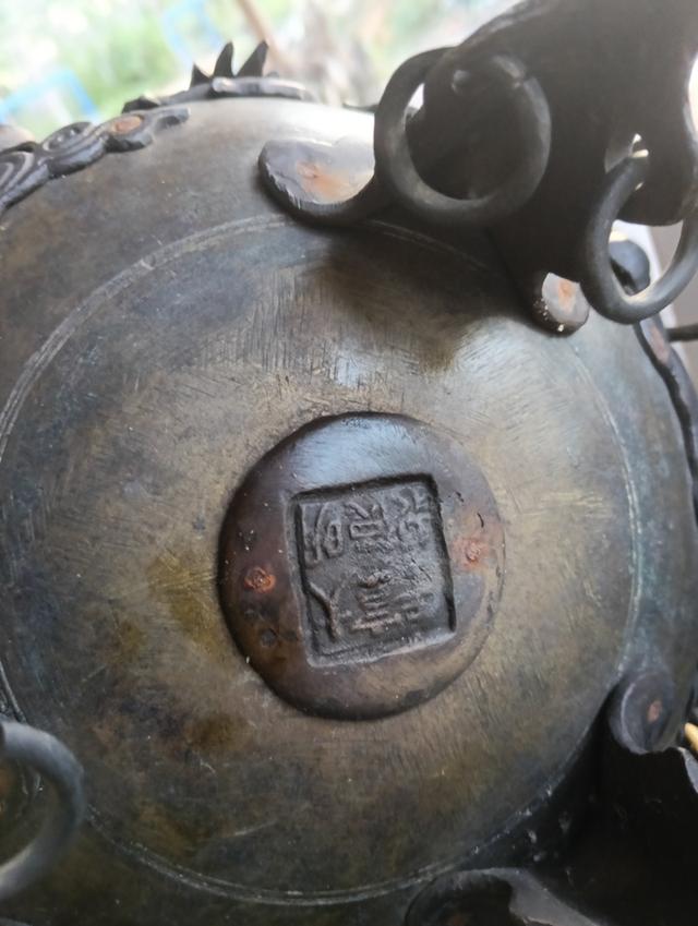 กระถางธูปสามขา (Tripod Censer) หรือเตากำยานสัมฤทธิ์สไตล์จีนโบราณ  ตัวกระถางเป็นทรงกลมป่อง มีลวดลายมังกรและเมฆอยู่รอบๆ  ฝาด้านบนมีรูปปั้นมังกรหรือสัตว 2