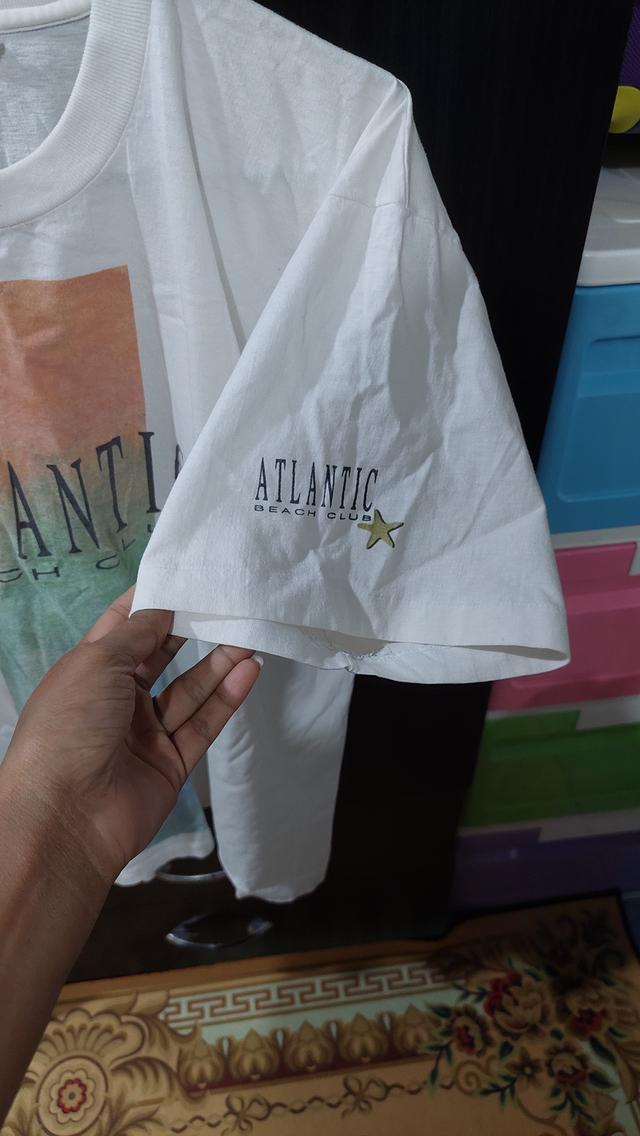 เสื้อยืดเป็นเสื้อวินเทจสีขาวลายกราฟิกด้านหน้าพร้อมตัวอักษร "ATLANTIC BEACH CLUB รูปย่อยที่ 3