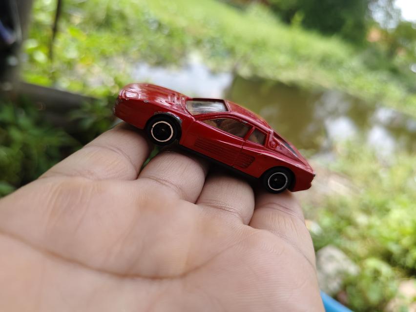 รถของเล่นในภาพคือ Tomica No. 91 Ferrari Testarossa เป็นโมเดลรถจำลองมาตราส่วน 1/60 ผลิตโดย Tomy ในปี 1988