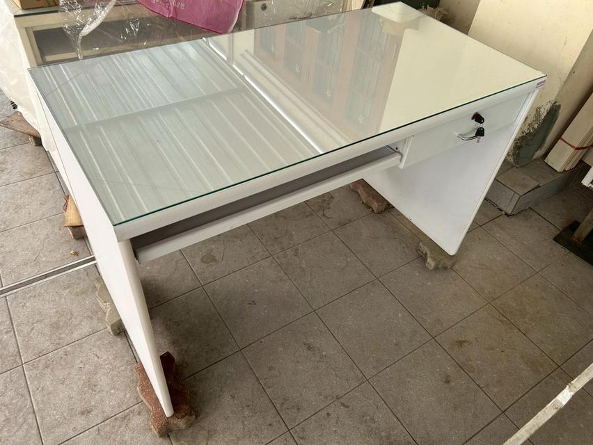 โต๊ะทำงานสีขาว ราคา 1,200 บาท ก120xล60xส75 ซม. กระจกปูโต๊ะ 4 มม.ลบมุมเรียบ เก๊ะด้านขวามีลูกกุญแจล็อคได้ เก๊ะกลางรางเลื่อน ด้านหน้าโต๊ะเว้นระยะหัวเข่า 4