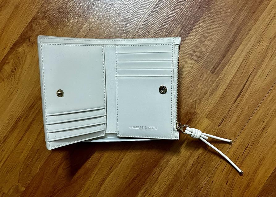 กระเป๋าสตางค์ CHARLES & KEITH ใบสั้นพับสองทบ โดดเด่นด้วยดีเทล สายดึงซิปผูกปม (Knot Charm) พร้อมช่องใส่บัตร และช่องซิปใส่เหรียญ ราคาช็อปไทย: 1,590 บาท รูปย่อยที่ 3