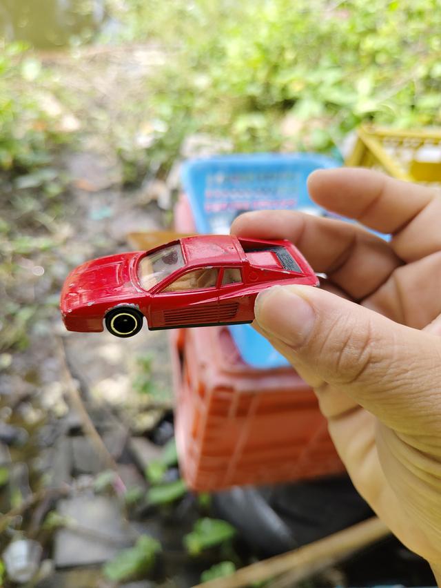 รถของเล่นในภาพคือ Tomica No. 91 Ferrari Testarossa เป็นโมเดลรถจำลองมาตราส่วน 1/60 ผลิตโดย Tomy ในปี 1988