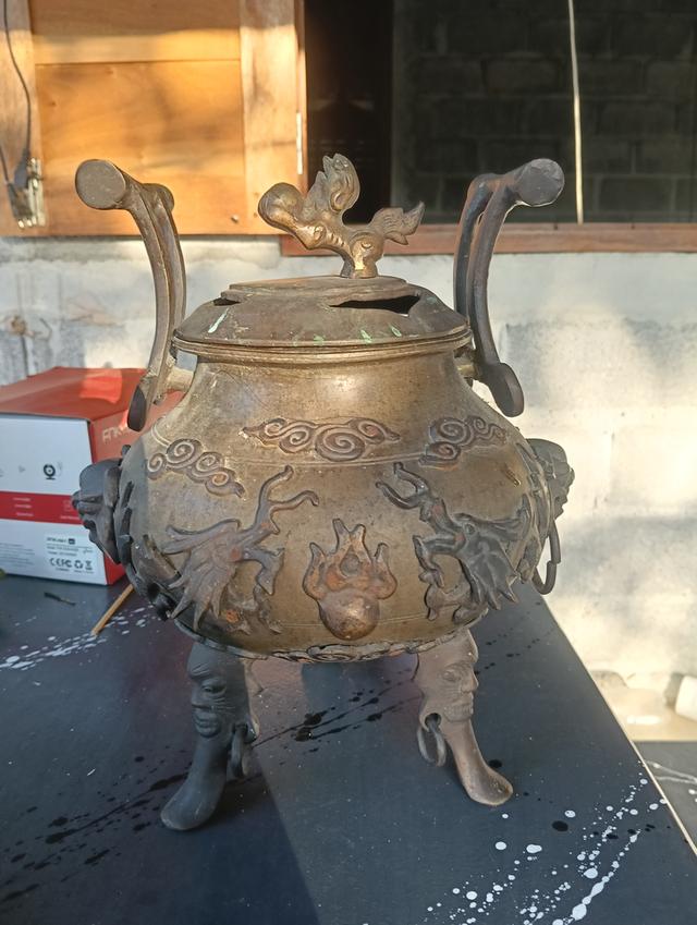 กระถางธูปสามขา (Tripod Censer) หรือเตากำยานสัมฤทธิ์สไตล์จีนโบราณ  ตัวกระถางเป็นทรงกลมป่อง มีลวดลายมังกรและเมฆอยู่รอบๆ  ฝาด้านบนมีรูปปั้นมังกรหรือสัตว