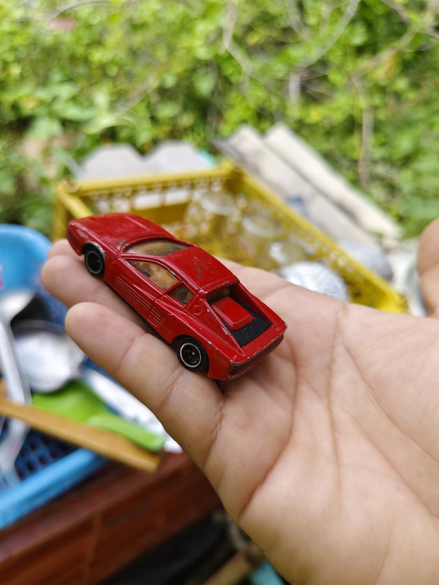 รถของเล่นในภาพคือ Tomica No. 91 Ferrari Testarossa เป็นโมเดลรถจำลองมาตราส่วน 1/60 ผลิตโดย Tomy ในปี 1988
