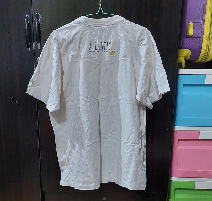 เสื้อยืดเป็นเสื้อวินเทจสีขาวลายกราฟิกด้านหน้าพร้อมตัวอักษร "ATLANTIC BEACH CLUB รูปย่อยที่ 2