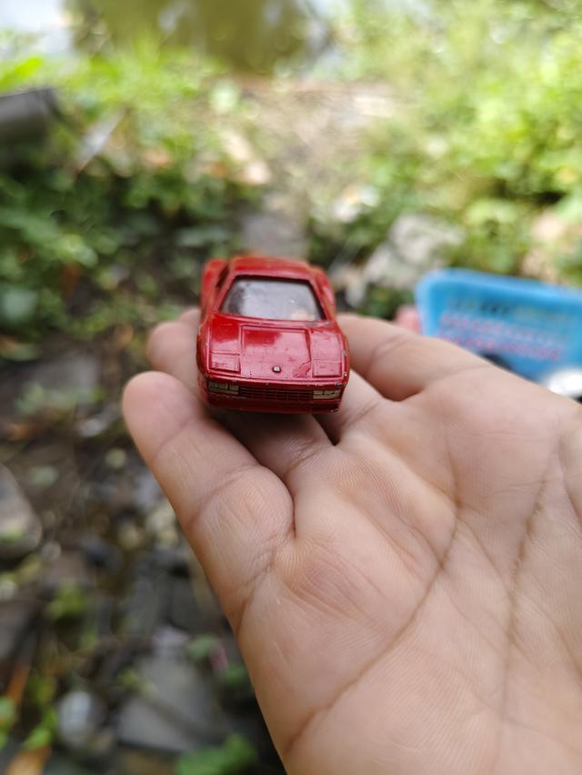 รถของเล่นในภาพคือ Tomica No. 91 Ferrari Testarossa เป็นโมเดลรถจำลองมาตราส่วน 1/60 ผลิตโดย Tomy ในปี 1988