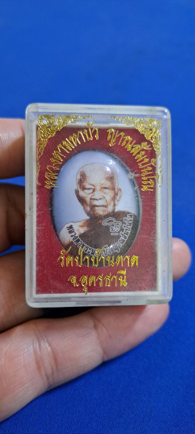 ล็อกเก็ตหลวงตาบัว ด้านหลังติดจีวรและตะกรุด