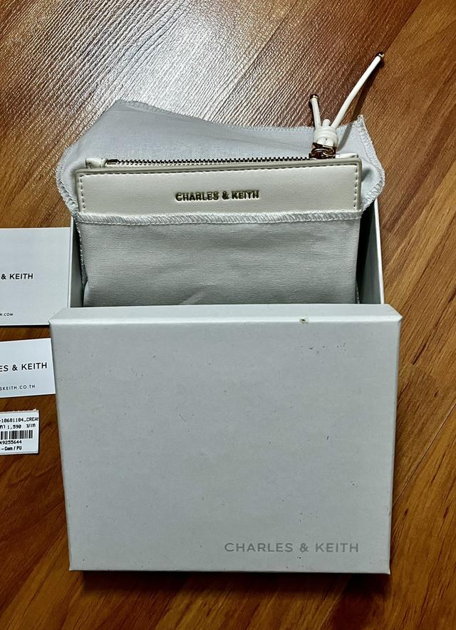 กระเป๋าสตางค์ CHARLES & KEITH ใบสั้นพับสองทบ โดดเด่นด้วยดีเทล สายดึงซิปผูกปม (Knot Charm) พร้อมช่องใส่บัตร และช่องซิปใส่เหรียญ ราคาช็อปไทย: 1,590 บาท รูปย่อยที่ 4