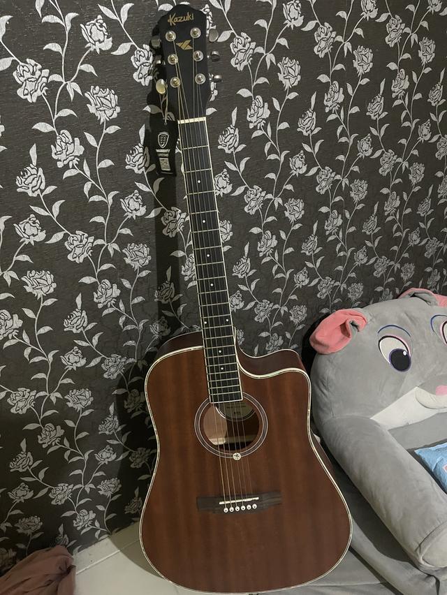 กีต้าร์ kazaki สีน้ำตาลอ่อนลายไม้ส่วนมีตำหนิไม้ถลอกนิดหน่อยแต่ไม่มีปัญหาต่อการใช้งานเสียงใส มีกระเป๋าแถมให้