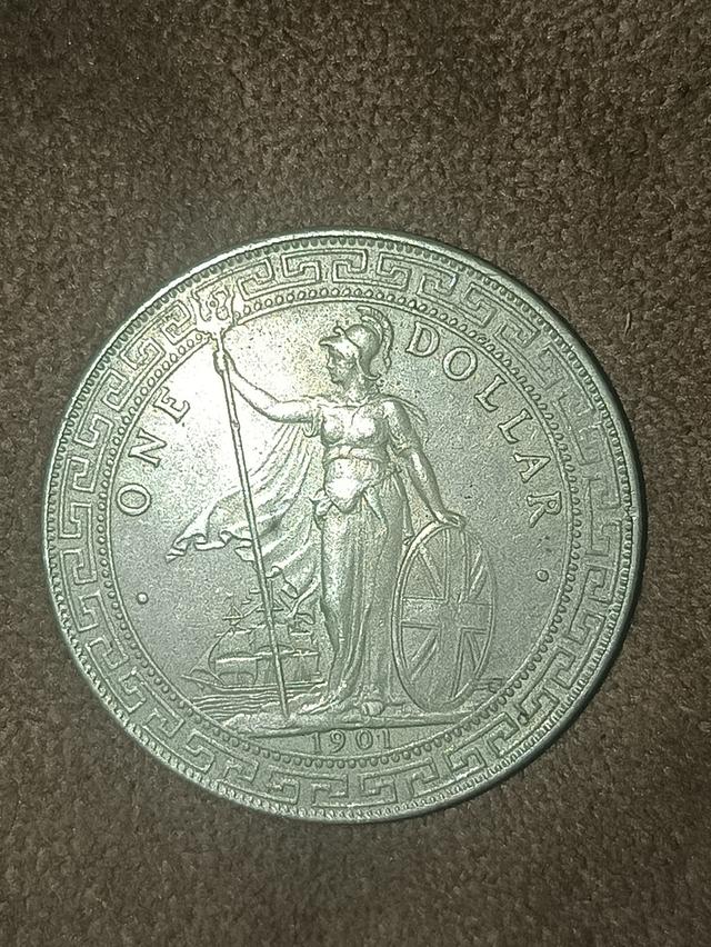เหรียญเทรดดอลลาร์บริทาเนีย (British Trade Dollar) ของสหราชอาณาจักร ด้านหลังเป็นรูปเทพีบริทาเนียยืนถือตรีศูลและโล่ พร้อมระบุปี ค.ศ. 1901 "ONE DOLLAR" .
