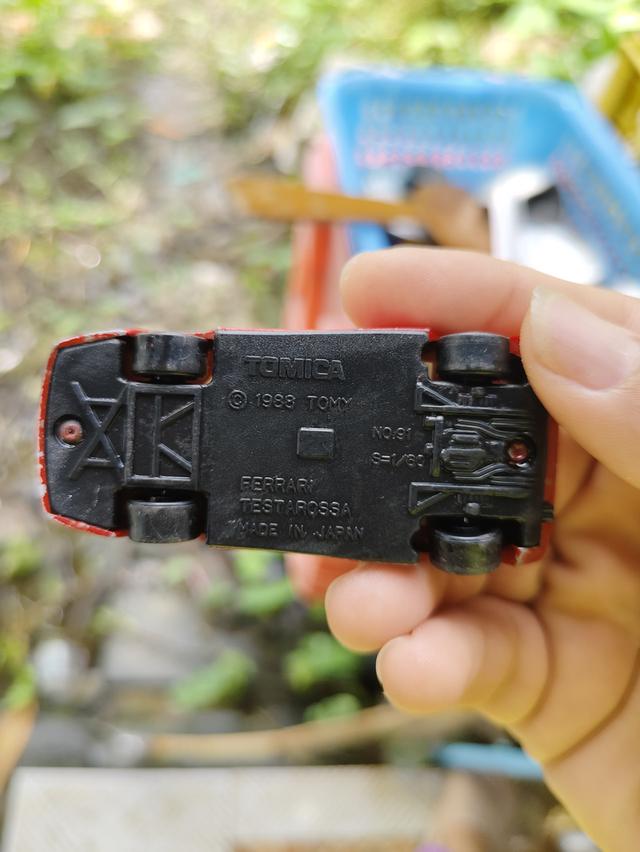 รถของเล่นในภาพคือ Tomica No. 91 Ferrari Testarossa เป็นโมเดลรถจำลองมาตราส่วน 1/60 ผลิตโดย Tomy ในปี 1988